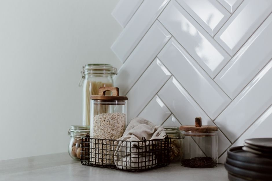 Stylish kitchen setup featuring glass jars with pasta and grains on a clean counter